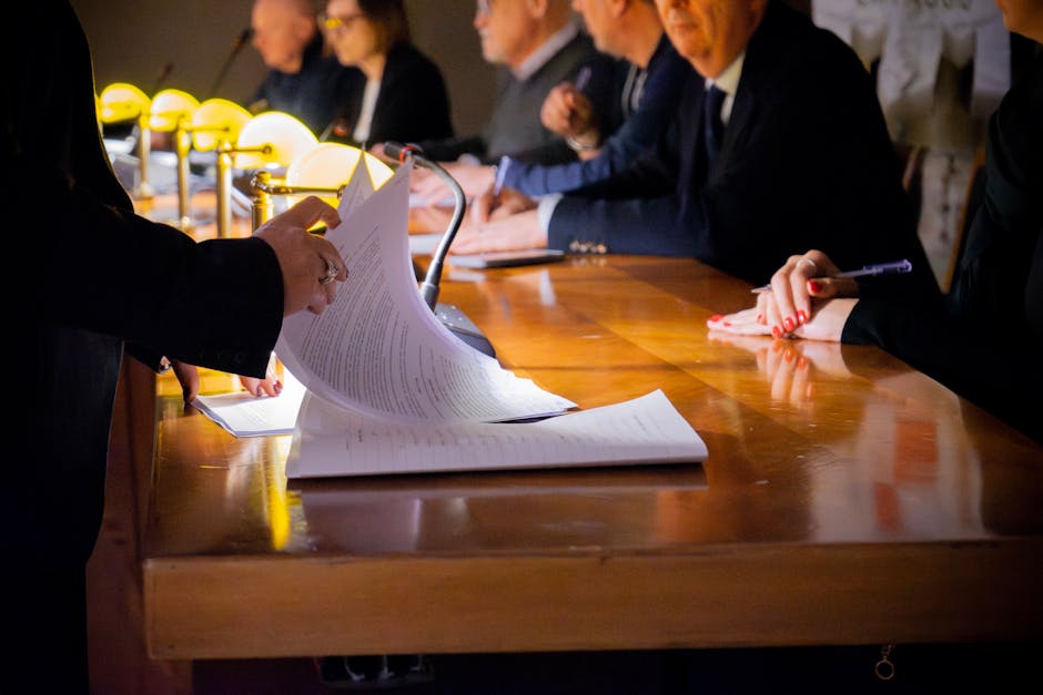 Close-up of a business meeting table with documents being reviewed and signed in Bergamo, Italy.